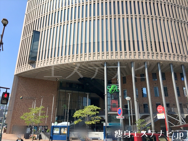 交差点手前左手に神戸国際会館があり１３階にシーズラボ 三宮店があります。